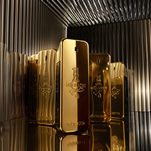 Goldene Parfumflakons der Million Duftlinie von Rabanne stehen spiegelnd vor einem goldenen, strukturierten Hintergrund.